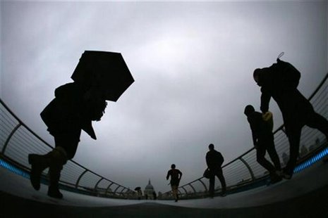 Commuters cross the Millennium Bridge during a rainy morning, towards the financial district the City of London November 27, 2012. REUTERS/S Commuters cross the Millennium Bridge during a rainy morning, towards the financial district the City of London November 27, 2012. REUTERS/S