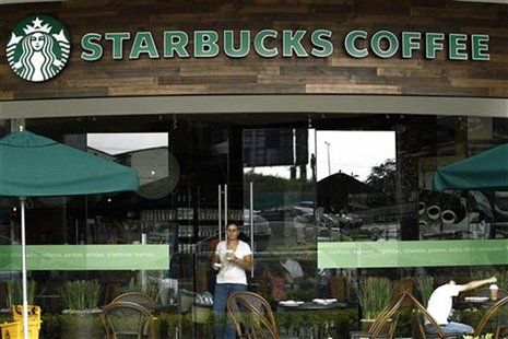 A customer with a cup of coffee leaves the new Starbucks store in San Jose June 20, 2012. REUTERS/Juan Carlos Ulate A customer with a cup of coffee leaves the new Starbucks store in San Jose June 20, 2012. REUTERS/Juan Carlos Ulate
