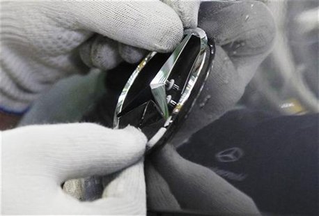 An employee of German car manufacturer Mercedes Benz fixes a logo on a new Mercedes A-class car at the Mercedes plant in Rastatt July 16, 20 An employee of German car manufacturer Mercedes Benz fixes a logo on a new Mercedes A-class car at the Mercedes plant in Rastatt July 16, 20