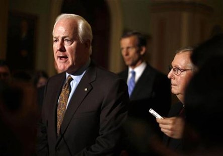 U.S. Senate Minority Leader Mitch McConnell (R-KY)(R) watches as John Cornyn (R-TX) speaks to the press on Capitol Hill in Washington, Novem U.S. Senate Minority Leader Mitch McConnell (R-KY)(R) watches as John Cornyn (R-TX) speaks to the press on Capitol Hill in Washington, Novem