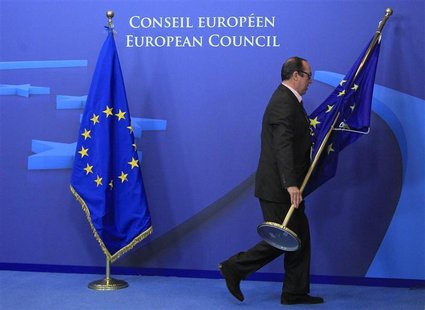 An employee at the EU council adjusts European Union flags at the entrance of the council headquarters for an European Union leaders summit An employee at the EU council adjusts European Union flags at the entrance of the council headquarters for an European Union leaders summit