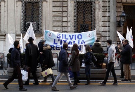 Residents walk past a banner reading "Silvio, Italy believes in you" hung outside former Prime Minister Silvio Berlusconi's home in central Residents walk past a banner reading "Silvio, Italy believes in you" hung outside former Prime Minister Silvio Berlusconi's home in central