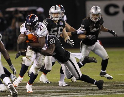 Denver Broncos running back Knowshon Moreno is tackled by Oakland Raiders cornerback Ron Bartell during their NFL football game in Oakland, Denver Broncos running back Knowshon Moreno is tackled by Oakland Raiders cornerback Ron Bartell during their NFL football game in Oakland,