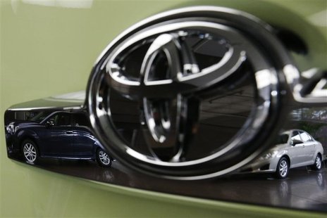 Toyota's Corolla Fielder (L) and Corolla Axio are reflected in a Toyota Forte's logo at the company's headquarters in Tokyo November 5, 2012 Toyota's Corolla Fielder (L) and Corolla Axio are reflected in a Toyota Forte's logo at the company's headquarters in Tokyo November 5, 2012