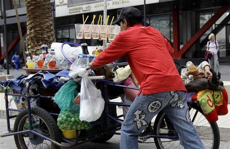 A street vendor selling soft drinks pushes his tricycle while his son lies on it on a street near the Zocalo main square in Mexico City July A street vendor selling soft drinks pushes his tricycle while his son lies on it on a street near the Zocalo main square in Mexico City July
