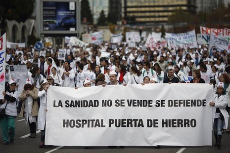 Demonstrators march behind a banner that reads: "Healthcare is not for sale, we have to defend it. Puerta de Hierro hospital" during a prote Demonstrators march behind a banner that reads: "Healthcare is not for sale, we have to defend it. Puerta de Hierro hospital" during a prote