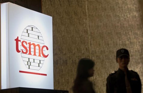 People stand behind a sign with a TSMC logo during TSMC's third quarter earnings conference in Taipei October 25, 2012. REUTERS/Yi-ting Chun People stand behind a sign with a TSMC logo during TSMC's third quarter earnings conference in Taipei October 25, 2012. REUTERS/Yi-ting Chun