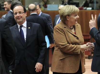 France's President Francois Hollande (L) walks past Germany's Chancellor Angela Merkel during a summit of European Union leaders discussing France's President Francois Hollande (L) walks past Germany's Chancellor Angela Merkel during a summit of European Union leaders discussing