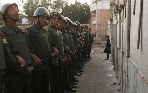 A boy leans against a newly built barrier, in front of soldiers standing guard outside the Egyptian presidential palace in Cairo December 9, A boy leans against a newly built barrier, in front of soldiers standing guard outside the Egyptian presidential palace in Cairo December 9,