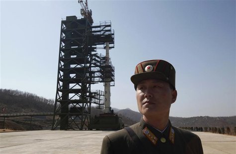 A soldier stands guard in front of a rocket sitting on a launch pad at the West Sea Satellite Launch Site, during a guided media tour by Nor A soldier stands guard in front of a rocket sitting on a launch pad at the West Sea Satellite Launch Site, during a guided media tour by Nor