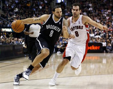 Brooklyn Nets Deron Williams drives to the net past Toronto Raptors Jose Calderon during the second half of their NBA basketball game in Tor Brooklyn Nets Deron Williams drives to the net past Toronto Raptors Jose Calderon during the second half of their NBA basketball game in Tor