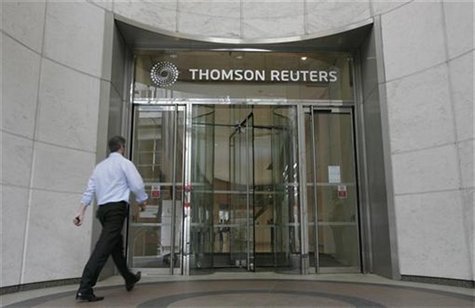 A worker enters the Thomson Reuters building in the Canary Wharf financial district of London August 6, 2009. REUTERS/Simon Newman A worker enters the Thomson Reuters building in the Canary Wharf financial district of London August 6, 2009. REUTERS/Simon Newman