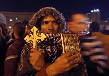 An anti-Mursi protester holds a Cross and a Koran at Tahrir Square in Cairo December 12, 2012. REUTERS/Khaled Abdullah An anti-Mursi protester holds a Cross and a Koran at Tahrir Square in Cairo December 12, 2012. REUTERS/Khaled Abdullah