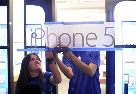 Apple employees hang an iPhone 5 sign at one of the company's retail locations shortly before sales began in San Francisco, California, Sept Apple employees hang an iPhone 5 sign at one of the company's retail locations shortly before sales began in San Francisco, California, Sept