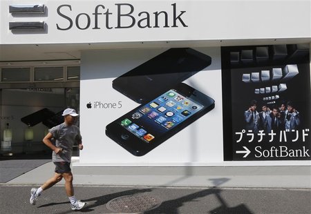 A jogger runs past a Softbank shop in Tokyo October 16, 2012. Softbank Corp's pricey $20 billion (12 billion pounds) bid to buy control of N A jogger runs past a Softbank shop in Tokyo October 16, 2012. Softbank Corp's pricey $20 billion (12 billion pounds) bid to buy control of N