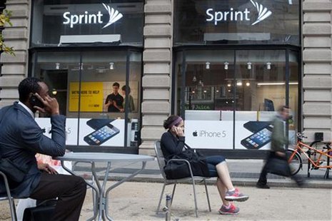 People talk on their cell phones as passers-by walk past a Sprint store in New York, October 15, 2012. REUTERS/Keith Bedford People talk on their cell phones as passers-by walk past a Sprint store in New York, October 15, 2012. REUTERS/Keith Bedford
