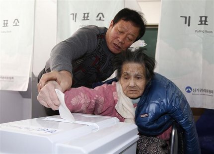 An elderly woman is assisted in casting her ballot in the presidential election at a polling station in Nonsan, about 190 km (118 miles) sou An elderly woman is assisted in casting her ballot in the presidential election at a polling station in Nonsan, about 190 km (118 miles) sou
