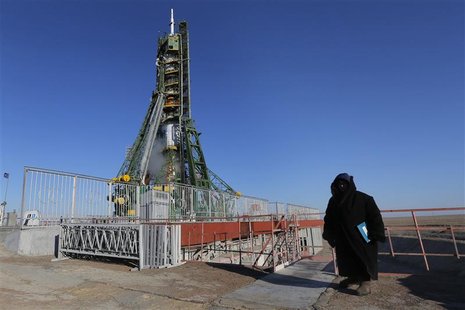 A security guard stands in front of the Soyuz TMA-07M spacecraft set on its launch pad before the blast off with the International Space Sta A security guard stands in front of the Soyuz TMA-07M spacecraft set on its launch pad before the blast off with the International Space Sta