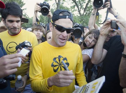 Lance Armstrong (C) signs autographs following a run with his fans at Mount Royal park in Montreal August 29, 2012. REUTERS/Christinne Musch Lance Armstrong (C) signs autographs following a run with his fans at Mount Royal park in Montreal August 29, 2012. REUTERS/Christinne Musch