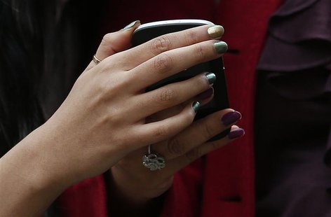 Two women look at a mobile phone on Oxford Street in London October 29, 2012. REUTERS/Suzanne Plunkett Two women look at a mobile phone on Oxford Street in London October 29, 2012. REUTERS/Suzanne Plunkett