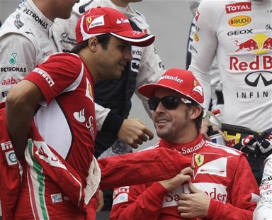 Ferrari Formula One driver Felipe Massa of Brazil (L) and team mate Fernando Alonso of Spain get ready for a group photo before the Brazilia Ferrari Formula One driver Felipe Massa of Brazil (L) and team mate Fernando Alonso of Spain get ready for a group photo before the Brazilia