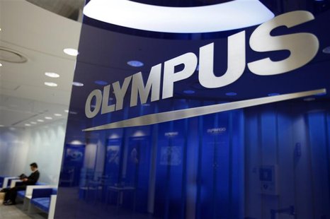 A man sits near a logo of Japan's Olympus Corp at the company headquarters in Tokyo June 19, 2012. REUTERS/Yuriko Nakao A man sits near a logo of Japan's Olympus Corp at the company headquarters in Tokyo June 19, 2012. REUTERS/Yuriko Nakao