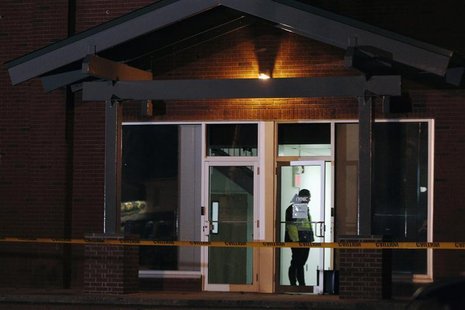 A Framingham police officer (in doorway) keeps watch as federal agents search th New England Compounding Center company in Framingham, Massa A Framingham police officer (in doorway) keeps watch as federal agents search th New England Compounding Center company in Framingham, Massa