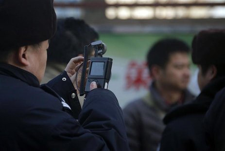 A policeman films his co-workers trying to persuade protesters from gathering near the Beijing Olympic Tower December 22, 2012. REUTERS/Peta A policeman films his co-workers trying to persuade protesters from gathering near the Beijing Olympic Tower December 22, 2012. REUTERS/Peta