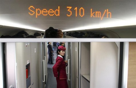 An attendant stands inside a high-speed train during an organized experience trip from Beijing to Zhengzhou, as part of a new rail line, Dec An attendant stands inside a high-speed train during an organized experience trip from Beijing to Zhengzhou, as part of a new rail line, Dec