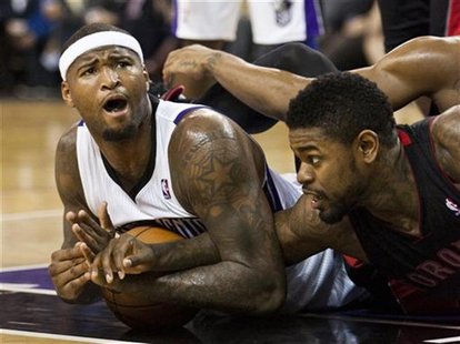 Sacramento Kings' DeMarcus Cousins (L) and Toronto Raptors' Amir Johnson (R) tangle over the ball during the second half of their NBA basket Sacramento Kings' DeMarcus Cousins (L) and Toronto Raptors' Amir Johnson (R) tangle over the ball during the second half of their NBA basket