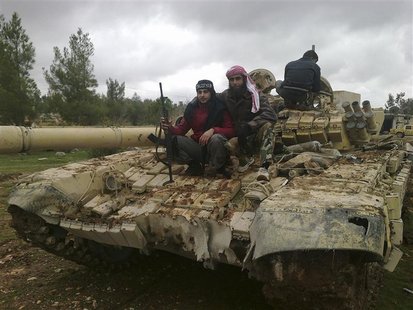 Free Syrian Army fighters pose near a tank after the fighters said they fought and defeated government troops in Al-Latameneh, near Hama Dec Free Syrian Army fighters pose near a tank after the fighters said they fought and defeated government troops in Al-Latameneh, near Hama Dec