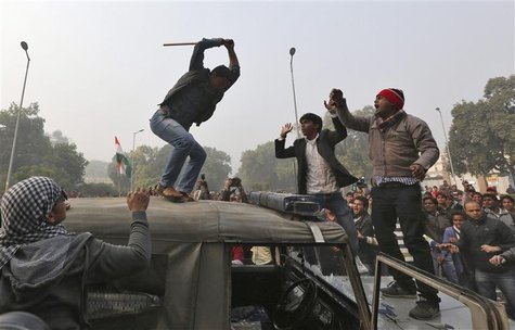 A demonstrator breaks the windshield of a police vehicle as others shout slogans in front of the India Gate during a protest in New Delhi De A demonstrator breaks the windshield of a police vehicle as others shout slogans in front of the India Gate during a protest in New Delhi De