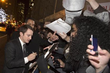Actor Elijah Wood signs autographs for fans at the premiere of the film "The Hobbit: An Unexpected Journey" in New York December 6, 2012. RE Actor Elijah Wood signs autographs for fans at the premiere of the film "The Hobbit: An Unexpected Journey" in New York December 6, 2012. RE