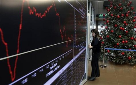 A woman stands next to an electronic board at the reception hall of the Athens stock exchange December 12, 2012. REUTERS/John Kolesidis A woman stands next to an electronic board at the reception hall of the Athens stock exchange December 12, 2012. REUTERS/John Kolesidis