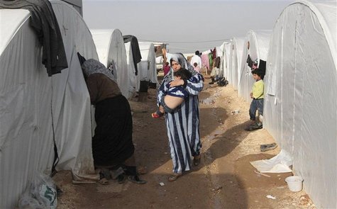 A Syrian refugee woman holds her child in the refugee camp of Bab El Salama, between the Syrian town of Azaz and the Turkish town of Kilis, A Syrian refugee woman holds her child in the refugee camp of Bab El Salama, between the Syrian town of Azaz and the Turkish town of Kilis,