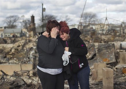 Neighbors Lucille Dwyer (R) and Linda Strong embrace after looking through the wreckage of their homes devastated by fire and the effects of Neighbors Lucille Dwyer (R) and Linda Strong embrace after looking through the wreckage of their homes devastated by fire and the effects of