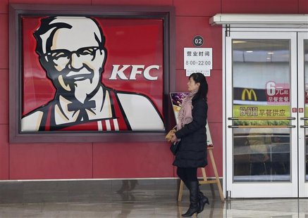 A woman walks past a KFC restaurant as a logo of McDonald is reflected on a door window, in Wuhan, Hubei province, December 18, 2012. REUTER A woman walks past a KFC restaurant as a logo of McDonald is reflected on a door window, in Wuhan, Hubei province, December 18, 2012. REUTER