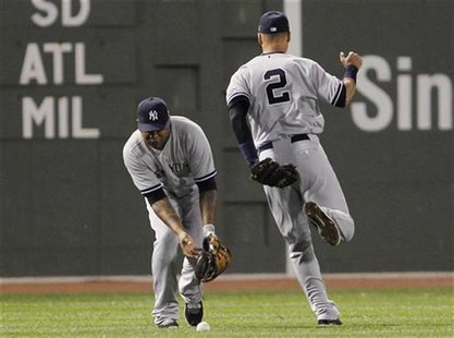 New York Yankees right fielder Andruw Jones (L) bobbles a ball hit by Boston Red Sox's Dustin Pedroia (not pictured) after Yankees teammate New York Yankees right fielder Andruw Jones (L) bobbles a ball hit by Boston Red Sox's Dustin Pedroia (not pictured) after Yankees teammate