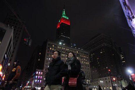 People walk near The Empire State Building as it is lit up in red and green on Christmas day in New York December 25, 2012. REUTERS/Eduardo People walk near The Empire State Building as it is lit up in red and green on Christmas day in New York December 25, 2012. REUTERS/Eduardo