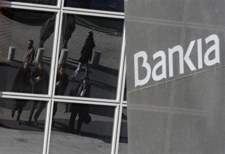 People are reflected on the windows of the headquarters of Spain's Bankia bank in Madrid November 28, 2012. REUTERS/Andrea Comas People are reflected on the windows of the headquarters of Spain's Bankia bank in Madrid November 28, 2012. REUTERS/Andrea Comas