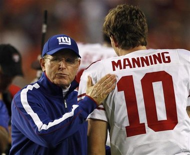 New York Giants head coach Tom Coughlin (L) wishes his starting quarterback Eli Manning (R) good luck prior to their NFL football game again New York Giants head coach Tom Coughlin (L) wishes his starting quarterback Eli Manning (R) good luck prior to their NFL football game again