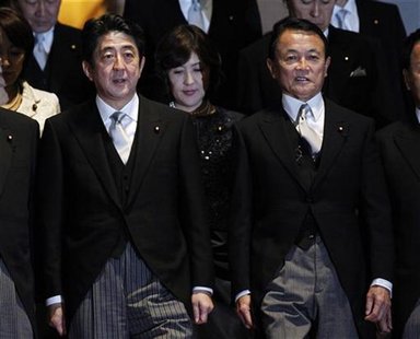 New Japanese Prime Minister Shinzo Abe (L) prepares for a photo session with Finance Minister Taro Aso and other ministers after their first New Japanese Prime Minister Shinzo Abe (L) prepares for a photo session with Finance Minister Taro Aso and other ministers after their first