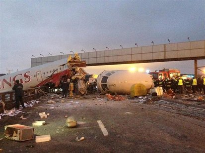 A wreckage of a plane is seen on a highway near Moscow's Vnukovo airport December 29, 2012. A Russian jet went off a runway and split into t A wreckage of a plane is seen on a highway near Moscow's Vnukovo airport December 29, 2012. A Russian jet went off a runway and split into t