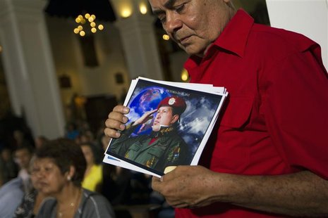 A supporter of Venezuelan President Hugo Chavez holds a picture of him, as he attends a mass to pray for Chavez's health in Caracas December A supporter of Venezuelan President Hugo Chavez holds a picture of him, as he attends a mass to pray for Chavez's health in Caracas December