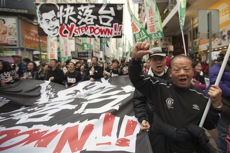 A protester gestures during a protest urging Hong Kong's Chief Executive Leung Chun-ying to step down, on a street in Hong Kong's shopping C A protester gestures during a protest urging Hong Kong's Chief Executive Leung Chun-ying to step down, on a street in Hong Kong's shopping C