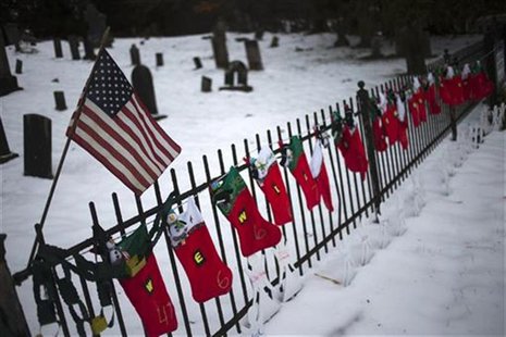 A U.S. flag hangs over stockings left as a memorial for victims of the Sandy Hook Elementary School shooting, along a fence surrounding the A U.S. flag hangs over stockings left as a memorial for victims of the Sandy Hook Elementary School shooting, along a fence surrounding the