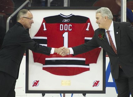 New Jersey Devils TV announcer Mike "Doc" Emrick shakes hands with Devils owner Jeff Vanderbeek (R) as he is presented a framed jersey while New Jersey Devils TV announcer Mike "Doc" Emrick shakes hands with Devils owner Jeff Vanderbeek (R) as he is presented a framed jersey while