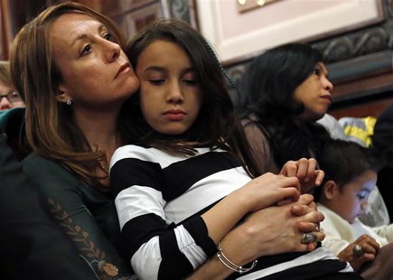 Theresa Volpe (L) holds her daughter Ava (2nd L) as her partner Mercedes Santos sits with their son Jaidon after testifying at the Illinois Theresa Volpe (L) holds her daughter Ava (2nd L) as her partner Mercedes Santos sits with their son Jaidon after testifying at the Illinois