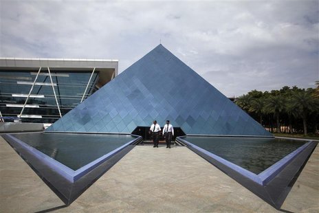 Employees walk in front of a pyramid-shaped building at the Infosys campus in the Electronic City area of Bangalore September 4, 2012. REUTE