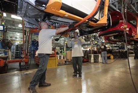 Ford Assembly workers Anthony Chwalek (L ) and Tom Downs install a battery charger underneath a Ford Focus Electric vehicle at the Michigan Ford Assembly workers Anthony Chwalek (L ) and Tom Downs install a battery charger underneath a Ford Focus Electric vehicle at the Michigan